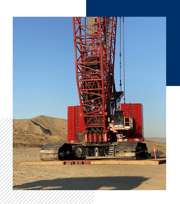 A red crane is in the middle of an open field.