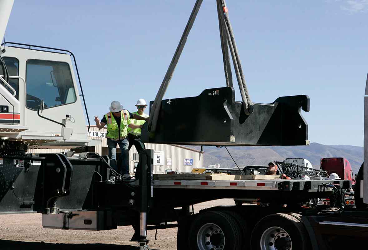 A man standing on the back of a truck.