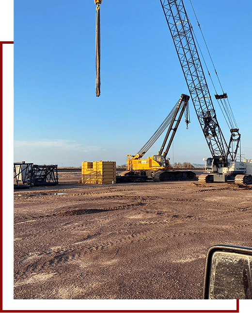 A large crane is in the middle of an empty field.